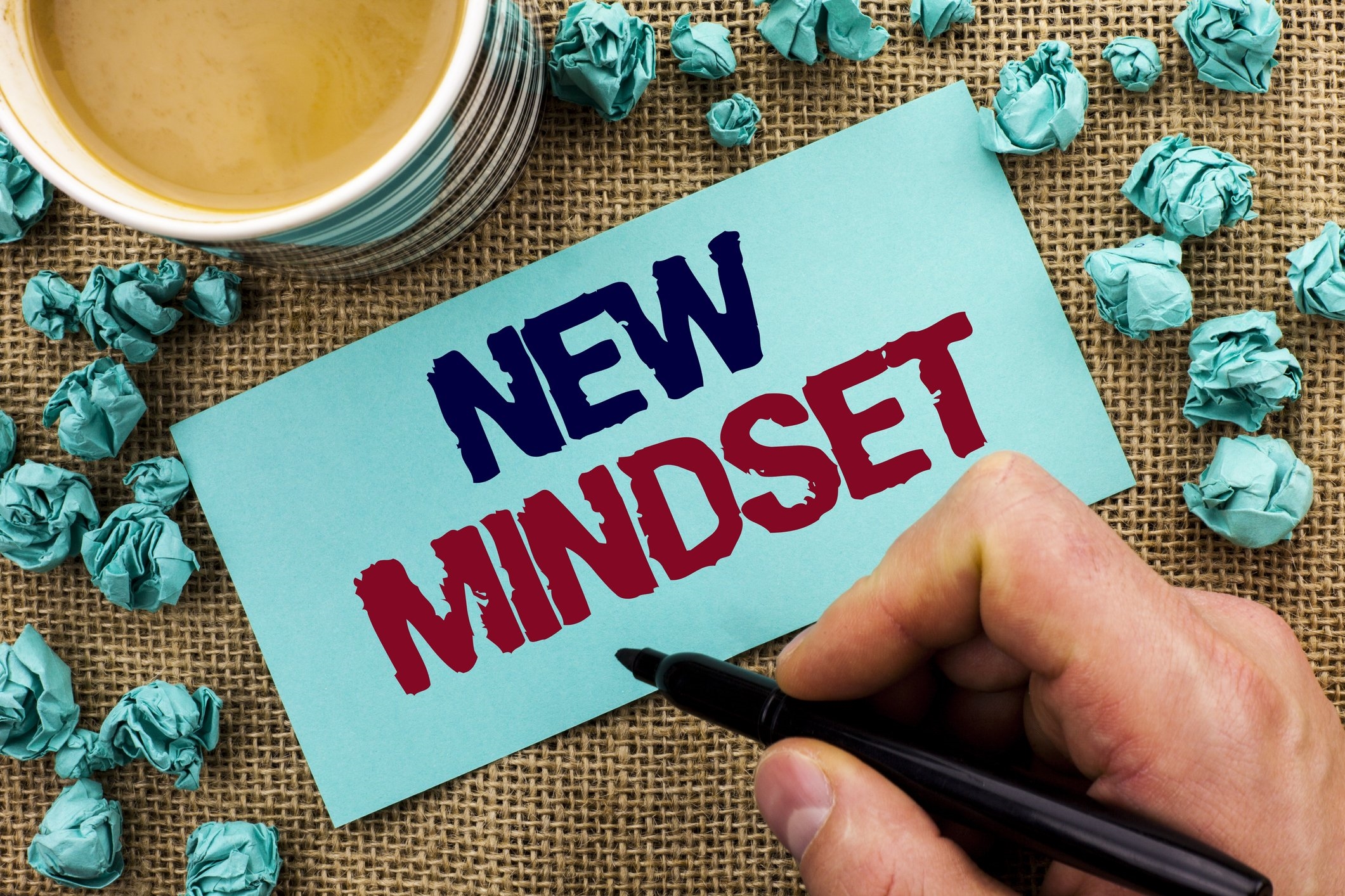Writing note showing New Mindset. Business photo showcasing Attitude Latest Concept Vision Behaviour Plan Thinking written by Man Holding Pen Sticky Note Paper the jute background Cup